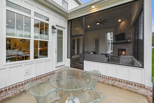 view of patio / terrace with outdoor dining space and an outdoor brick fireplace