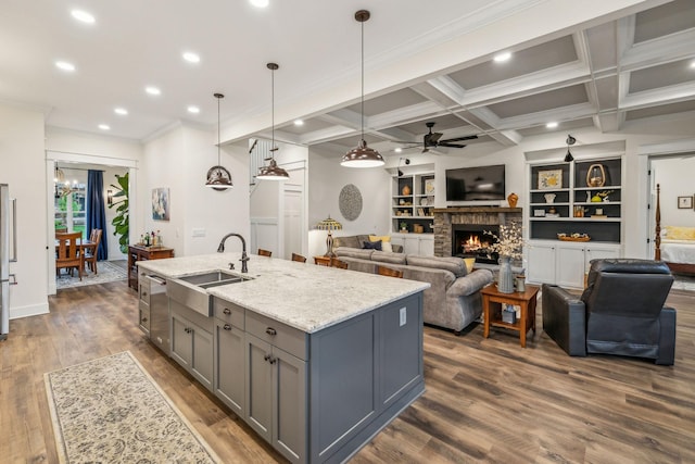 kitchen featuring a sink, ceiling fan with notable chandelier, a brick fireplace, gray cabinets, and dishwasher