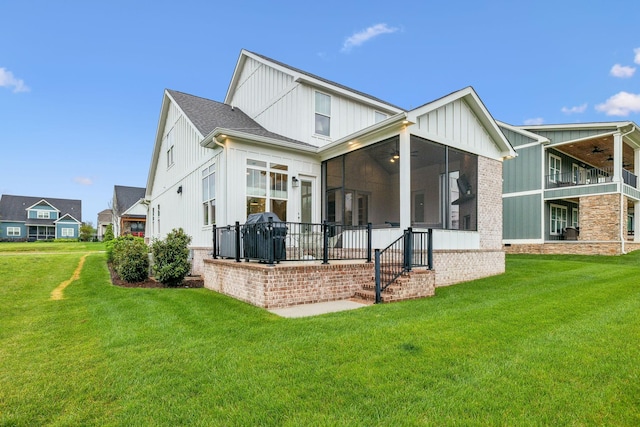 back of property featuring a lawn, a sunroom, board and batten siding, and ceiling fan