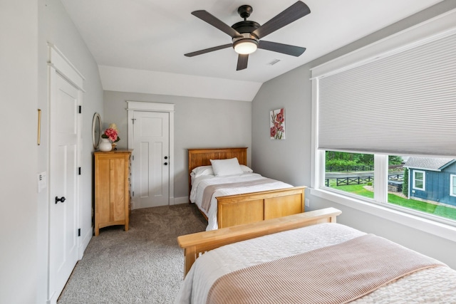 bedroom featuring light carpet, vaulted ceiling, visible vents, baseboards, and ceiling fan