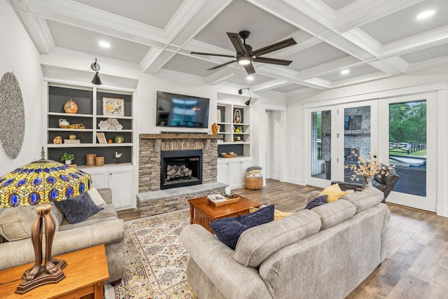living area featuring wood finished floors, ceiling fan, a fireplace, coffered ceiling, and beam ceiling