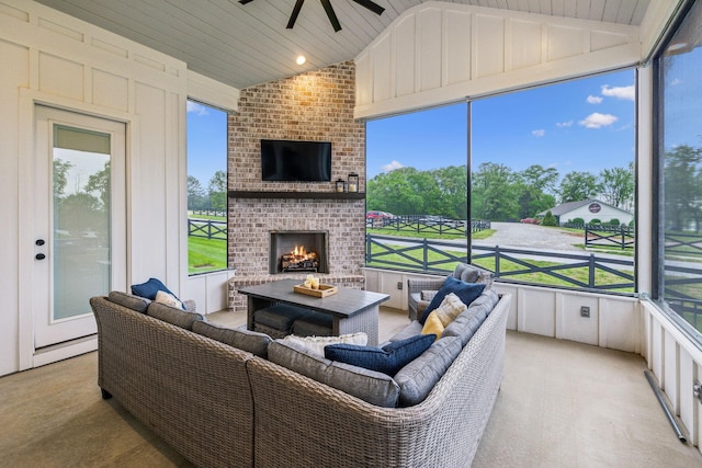 sunroom / solarium with an outdoor living space with a fireplace, lofted ceiling, a ceiling fan, and carpet