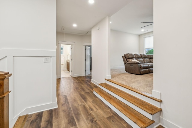 corridor featuring attic access, baseboards, wood finished floors, and recessed lighting