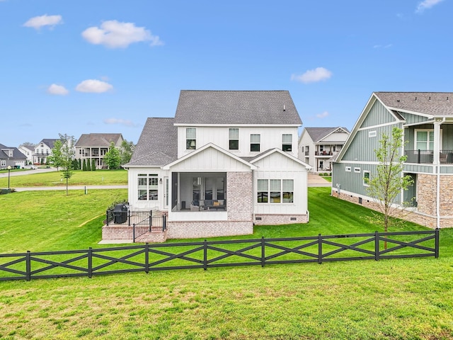 rear view of property with crawl space, board and batten siding, a fenced backyard, a yard, and a sunroom