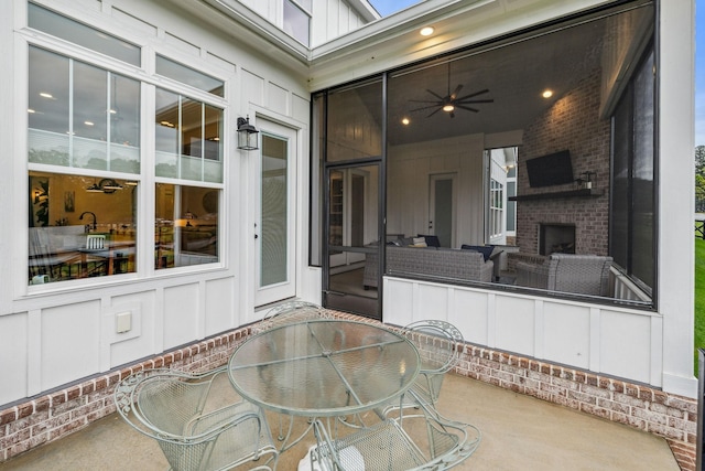 view of patio / terrace featuring outdoor dining space and an outdoor brick fireplace