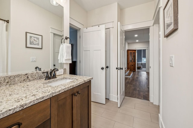 bathroom with baseboards, vanity, and tile patterned flooring