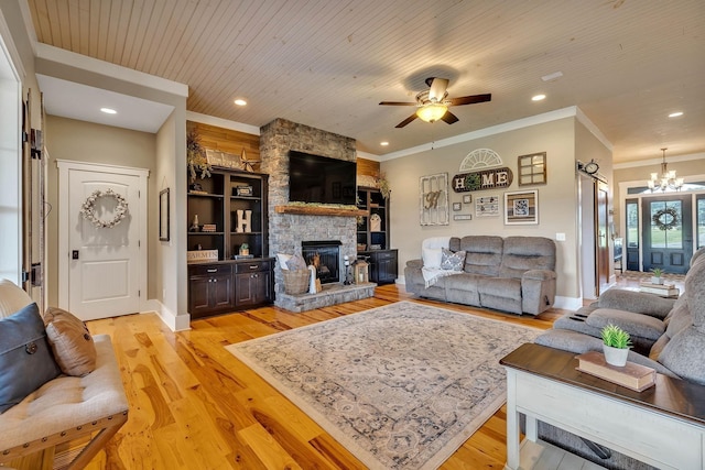 living area with light wood finished floors, recessed lighting, ceiling fan with notable chandelier, crown molding, and a stone fireplace
