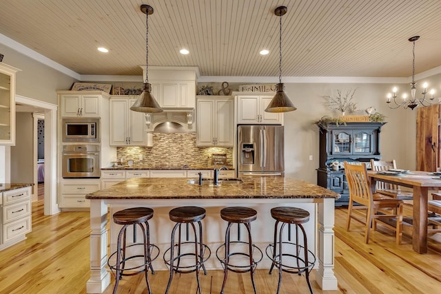 kitchen with a kitchen bar, crown molding, stainless steel appliances, and a sink