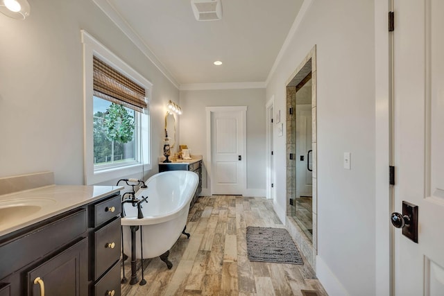 full bathroom with two vanities, a shower stall, ornamental molding, and a freestanding bath