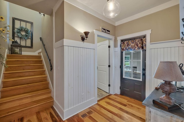 entrance foyer with light wood-type flooring, visible vents, and stairway