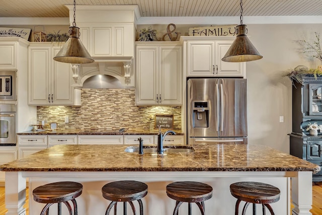 kitchen with a breakfast bar area, decorative backsplash, stainless steel appliances, and a sink