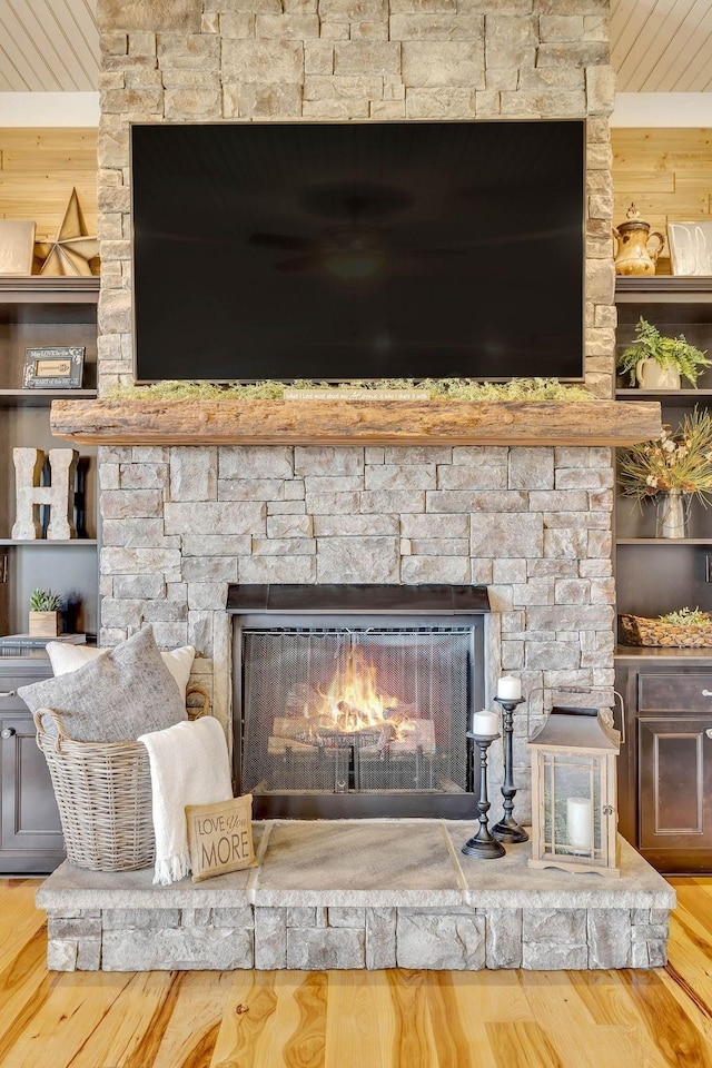 room details with wooden walls, wood finished floors, and a fireplace