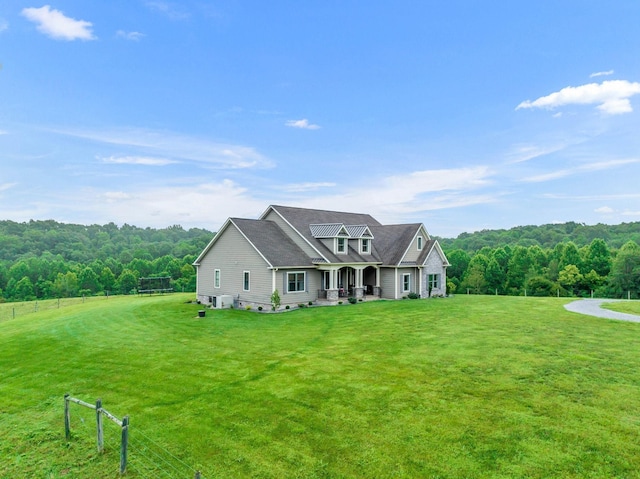 view of front of home with a front lawn and a view of trees