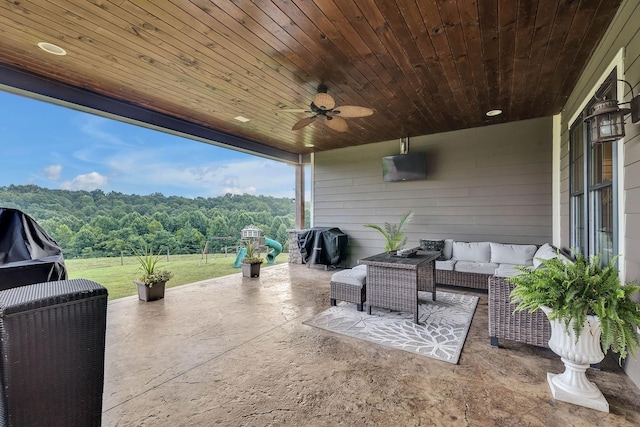 view of patio / terrace with outdoor lounge area, a view of trees, a grill, and ceiling fan