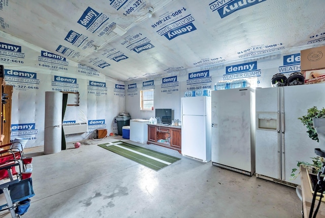 garage featuring freestanding refrigerator and white refrigerator with ice dispenser