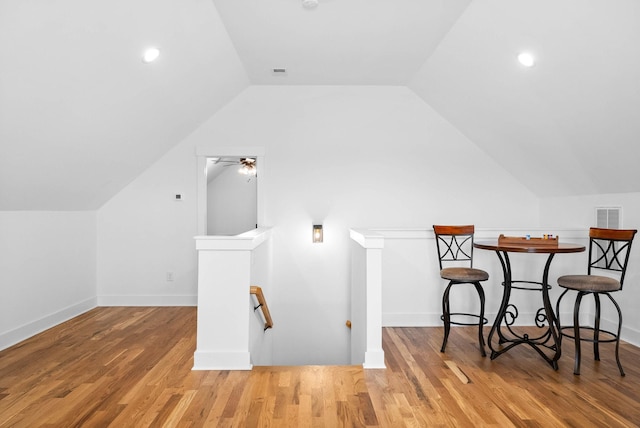 additional living space featuring lofted ceiling, wood finished floors, visible vents, and ceiling fan