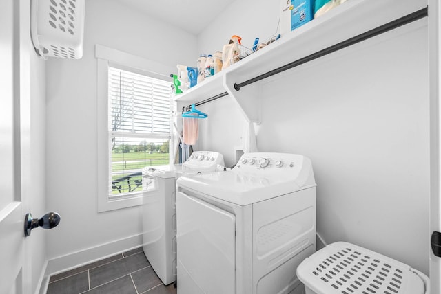 laundry room featuring washer and clothes dryer, baseboards, dark tile patterned flooring, and laundry area