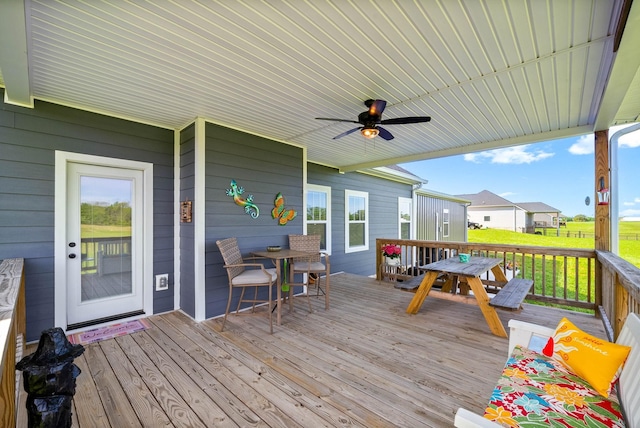 wooden deck with a ceiling fan and outdoor dining space