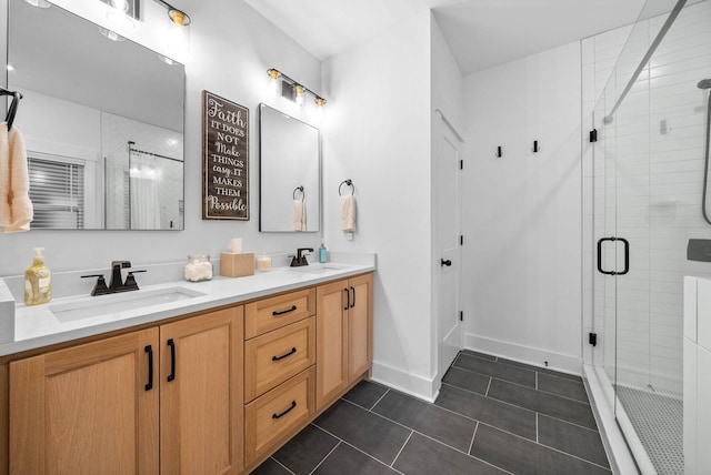 bathroom featuring double vanity, a shower stall, tile patterned floors, and a sink