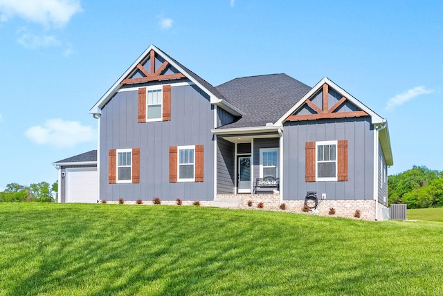 view of front of house with board and batten siding, roof with shingles, and a front lawn