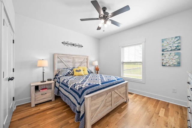 bedroom featuring ceiling fan, baseboards, and light wood-type flooring