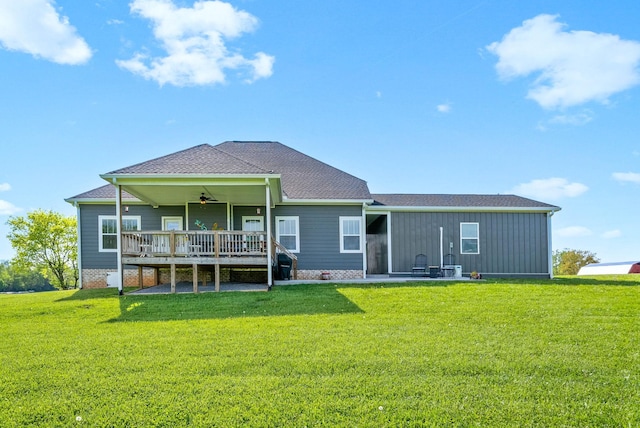 rear view of property featuring a wooden deck, a patio area, a ceiling fan, and a lawn