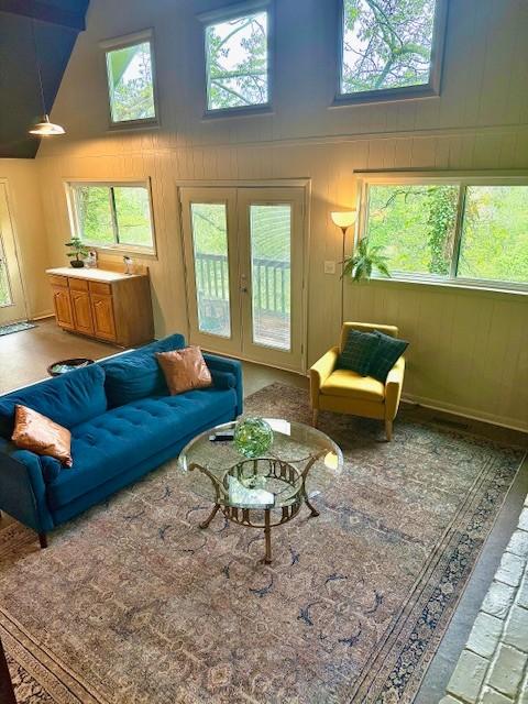 living room with french doors and high vaulted ceiling