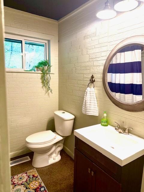 bathroom featuring visible vents, toilet, and vanity