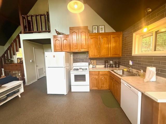 kitchen featuring light countertops, white appliances, a sink, and tasteful backsplash