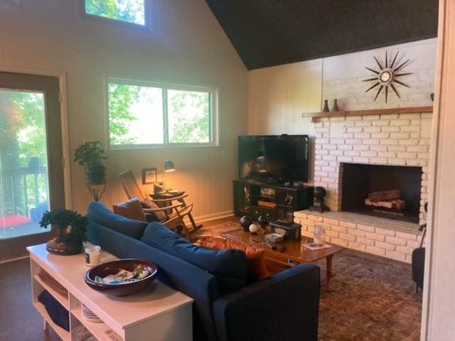 living room with a fireplace, high vaulted ceiling, a healthy amount of sunlight, and baseboards