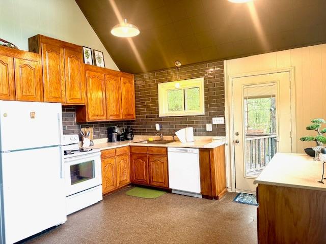 kitchen featuring brown cabinetry, vaulted ceiling, white appliances, and light countertops