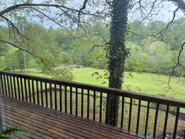 deck with a yard and a forest view