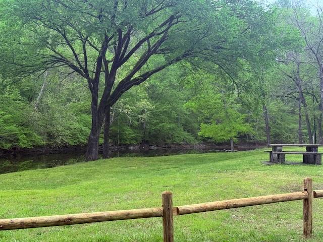 view of yard featuring fence and a wooded view