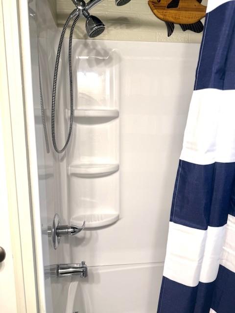 bathroom with shower / bathtub combination with curtain