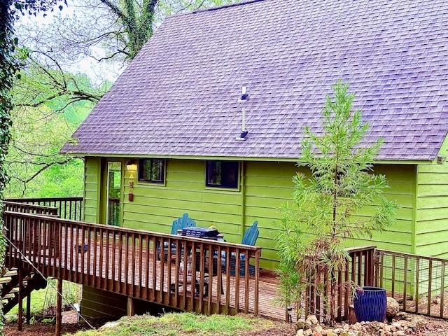 rear view of property featuring a wooden deck and roof with shingles