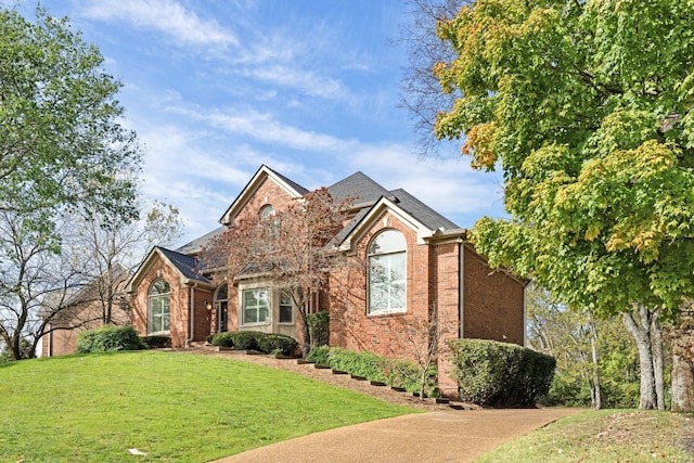 traditional home with brick siding and a front yard