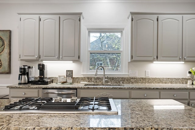 kitchen featuring light stone counters, appliances with stainless steel finishes, and a sink