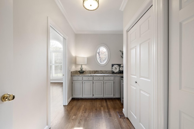 interior space with dark wood-type flooring and ornamental molding
