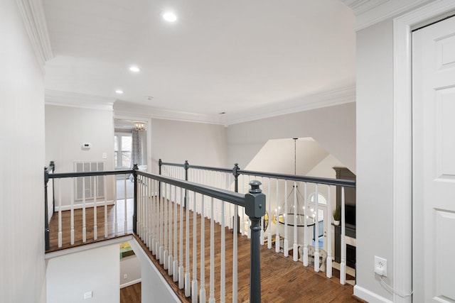 hall featuring recessed lighting, an upstairs landing, a notable chandelier, wood finished floors, and ornamental molding