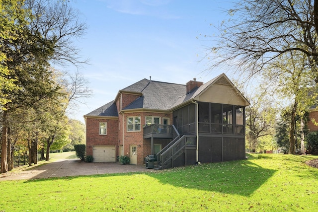 back of house with stairway, a yard, a garage, brick siding, and a sunroom