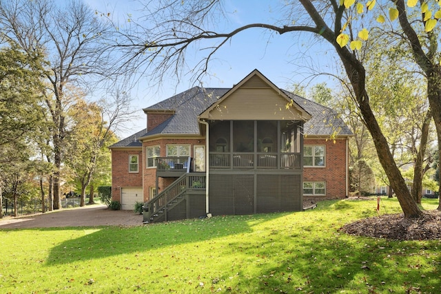 back of house with stairway, a lawn, an attached garage, brick siding, and a sunroom