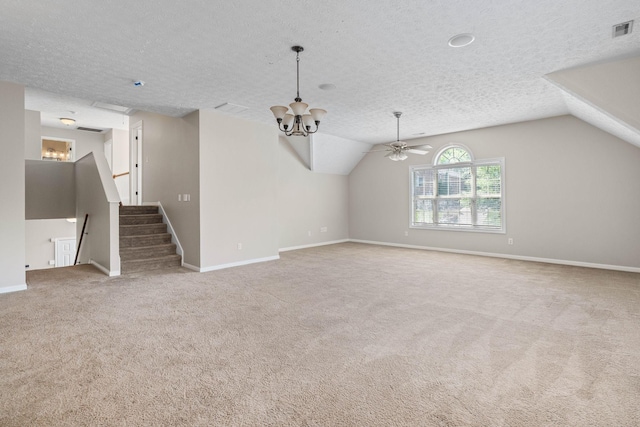 unfurnished living room featuring carpet floors, vaulted ceiling, baseboards, visible vents, and a textured ceiling