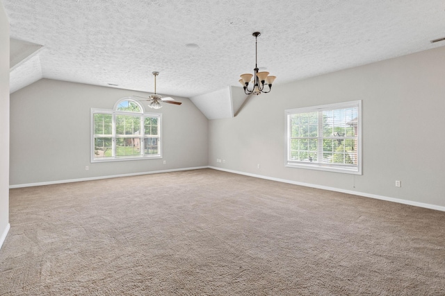 carpeted empty room featuring baseboards, vaulted ceiling, and a healthy amount of sunlight