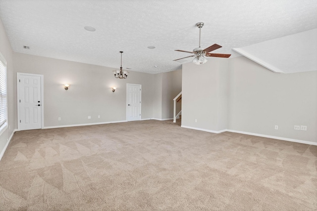 unfurnished living room featuring a textured ceiling, stairway, baseboards, carpet, and ceiling fan with notable chandelier
