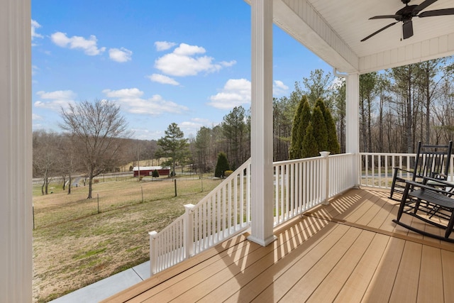 wooden deck with a yard and a ceiling fan