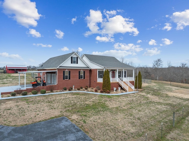 view of front of house featuring a porch, a front lawn, and brick siding
