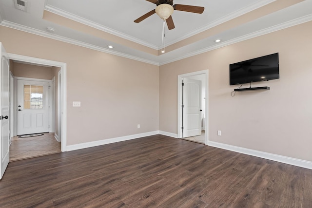 empty room with wood finished floors, a ceiling fan, visible vents, and a raised ceiling