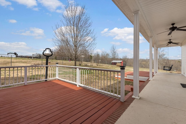 wooden deck with fence, a ceiling fan, and a yard