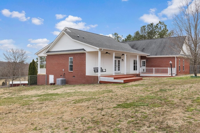 rear view of property with a yard, ceiling fan, a wooden deck, french doors, and brick siding