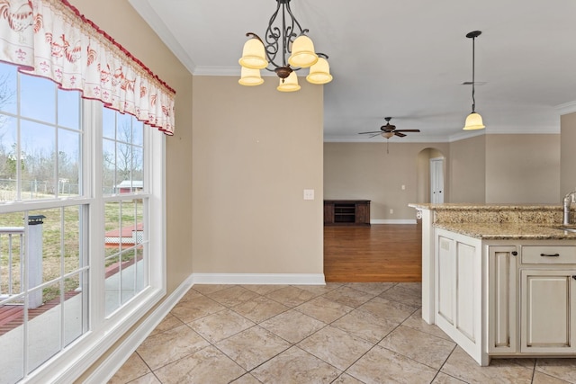 kitchen with arched walkways, decorative light fixtures, and ornamental molding